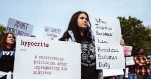 A group of protesters advocating for social justice and gender equality with impactful signs.